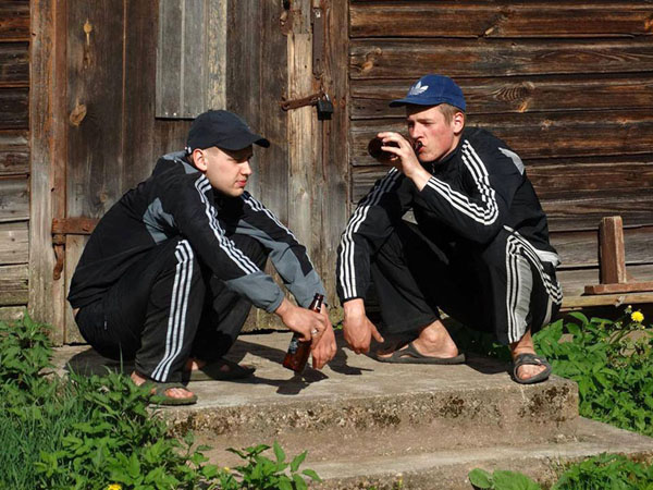 twee mannen doen de slav squat in adidas outfit