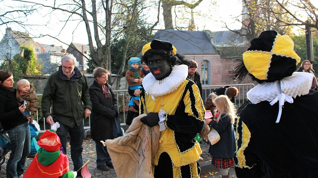 twee Zwarte Pieten delen strooigoed uit bij een intocht