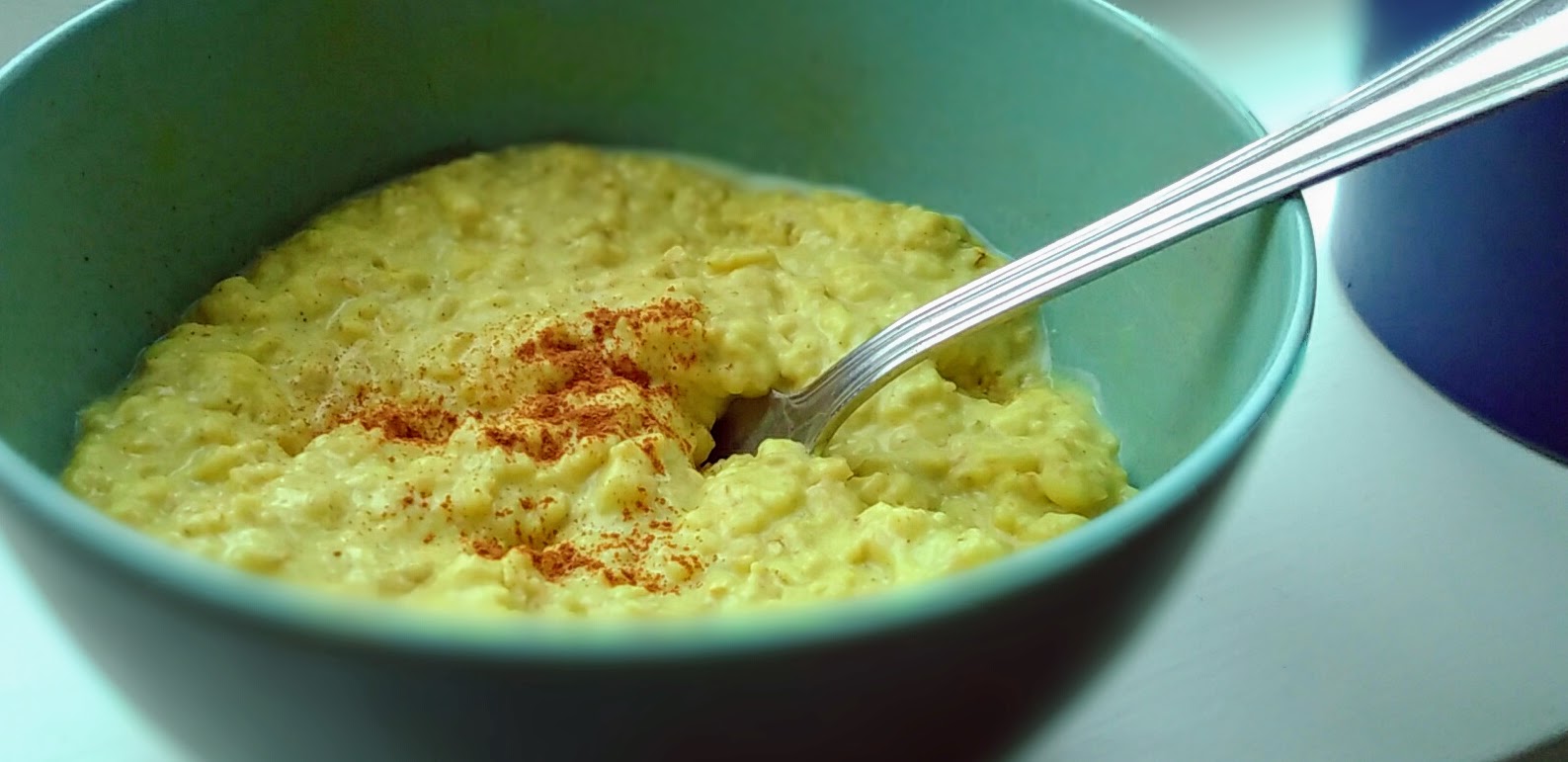 een close-up van een kom met golden milk oatmeal. Met een beetje kaneel erover.