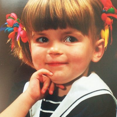 Een foto van mijzelf als klein meisje, gemaakt door een fotograaf. Ik heb een matrozenpakje aan en balonnetjes in mijn haar.